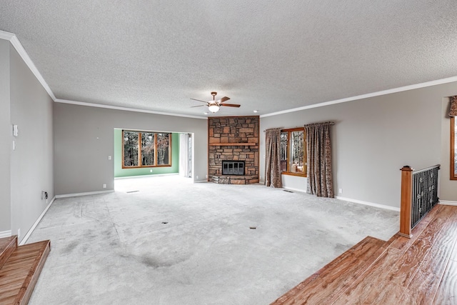 unfurnished living room with a fireplace, plenty of natural light, ornamental molding, and ceiling fan