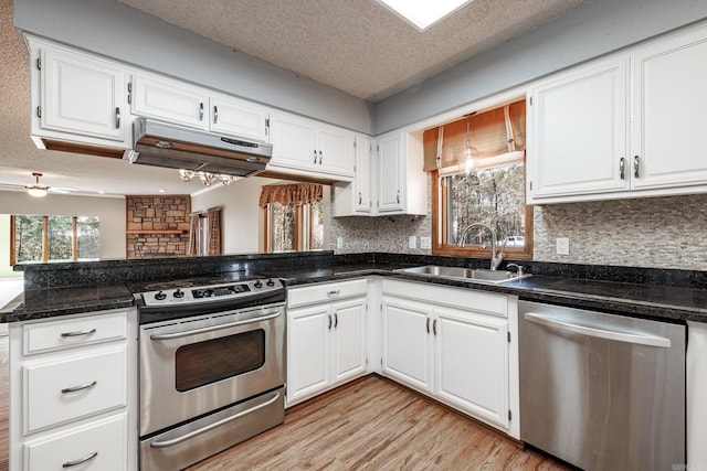 kitchen featuring white cabinets, sink, stainless steel appliances, and extractor fan