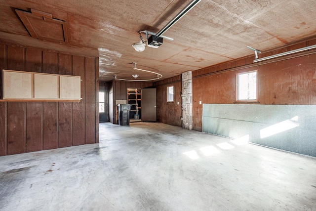 garage featuring wooden walls and a garage door opener