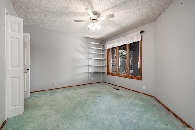 spare room with ceiling fan, carpet floors, and a textured ceiling