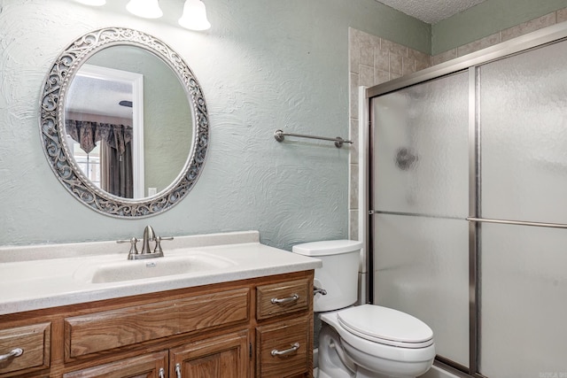 bathroom with vanity, toilet, and a shower with shower door