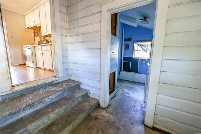 corridor featuring lofted ceiling and concrete floors