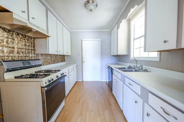 kitchen with white range with gas stovetop, sink, light hardwood / wood-style floors, and white cabinets