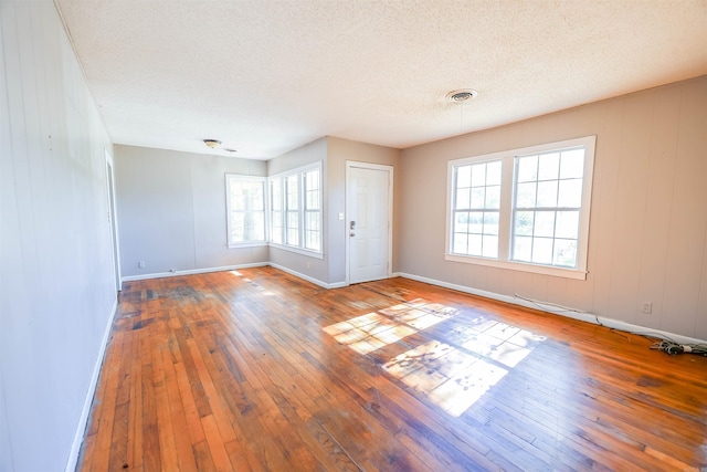 spare room featuring hardwood / wood-style floors and a textured ceiling