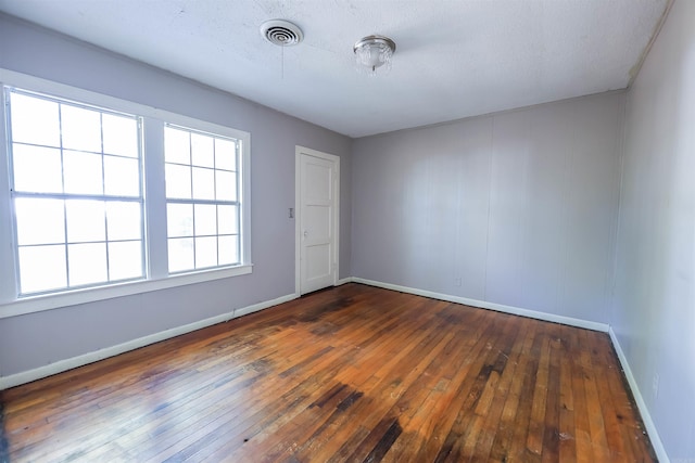 empty room featuring dark wood-type flooring and a textured ceiling