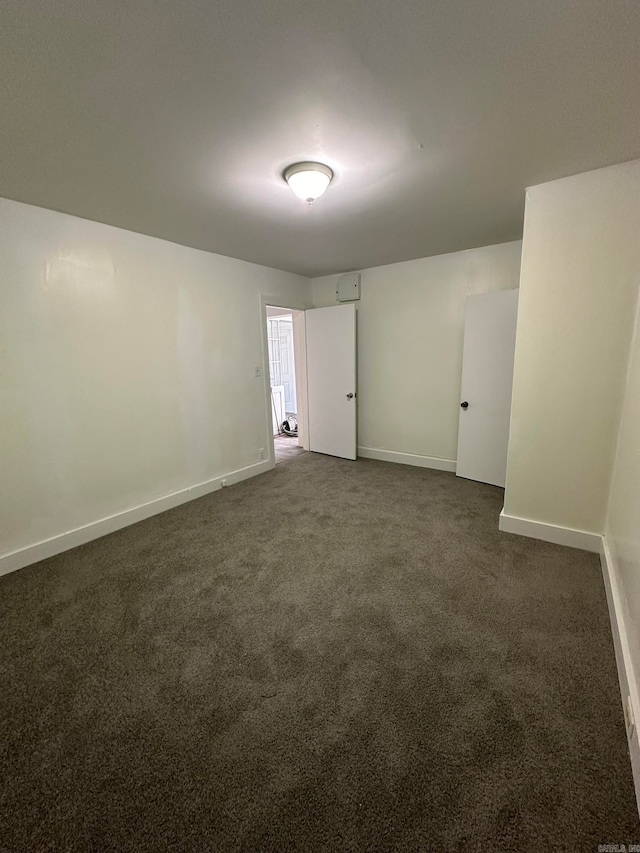 spare room featuring dark carpet