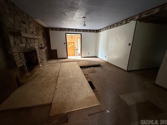 unfurnished room featuring a textured ceiling and a fireplace