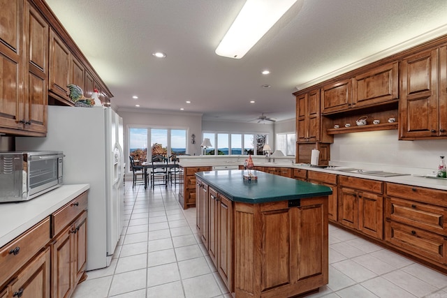 kitchen featuring kitchen peninsula, light tile patterned floors, ceiling fan, a kitchen island, and white appliances