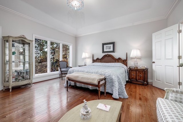 bedroom featuring hardwood / wood-style floors, an inviting chandelier, and ornamental molding