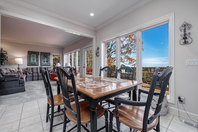 dining area featuring light tile patterned floors and crown molding