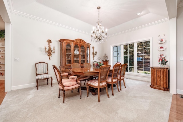 dining room with light hardwood / wood-style flooring, crown molding, a tray ceiling, and an inviting chandelier