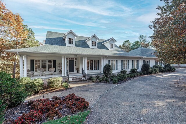 cape cod home featuring a porch