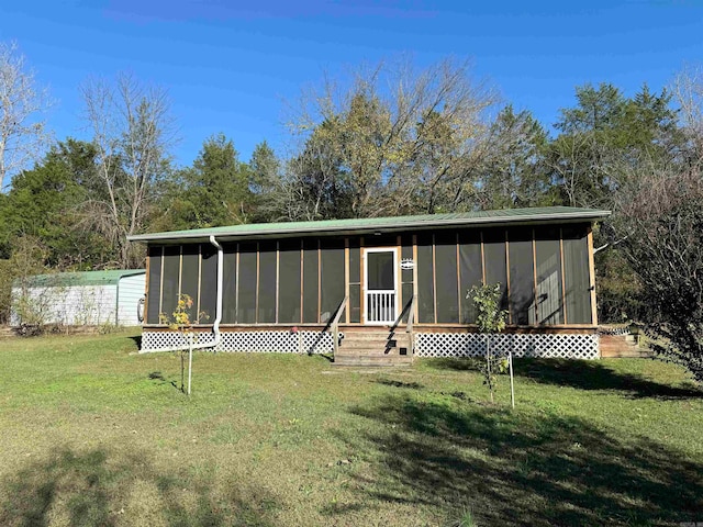 back of property featuring a lawn and a sunroom