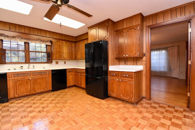 kitchen featuring wood walls, ceiling fan, and black appliances