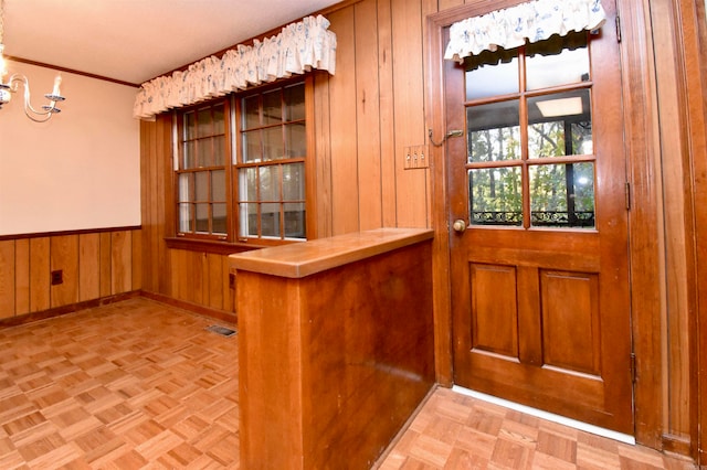 entryway with light parquet flooring and wood walls