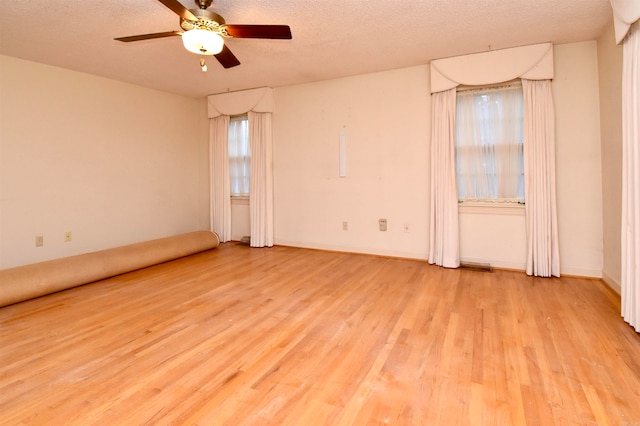 spare room featuring ceiling fan, a textured ceiling, and light wood-type flooring