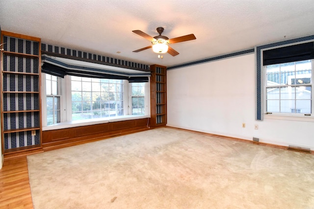 unfurnished room with hardwood / wood-style flooring, ceiling fan, and a textured ceiling