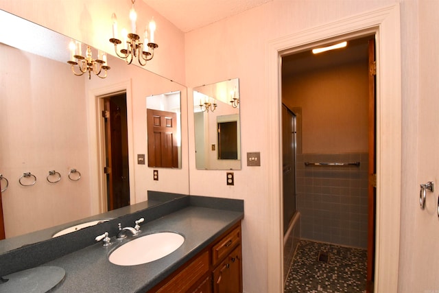 bathroom with a shower with shower door, vanity, tile walls, and a notable chandelier