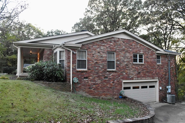 view of side of property featuring a garage, central AC, and a yard