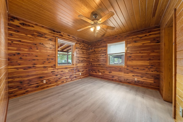 unfurnished room featuring wooden walls, hardwood / wood-style flooring, ceiling fan, and wood ceiling