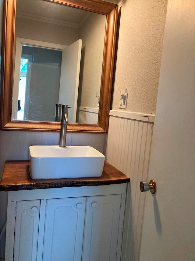 bathroom with vanity and ornamental molding