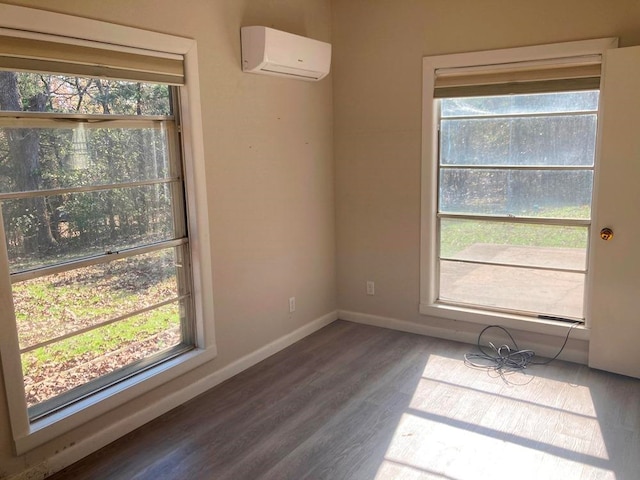 empty room featuring hardwood / wood-style floors and a wall unit AC