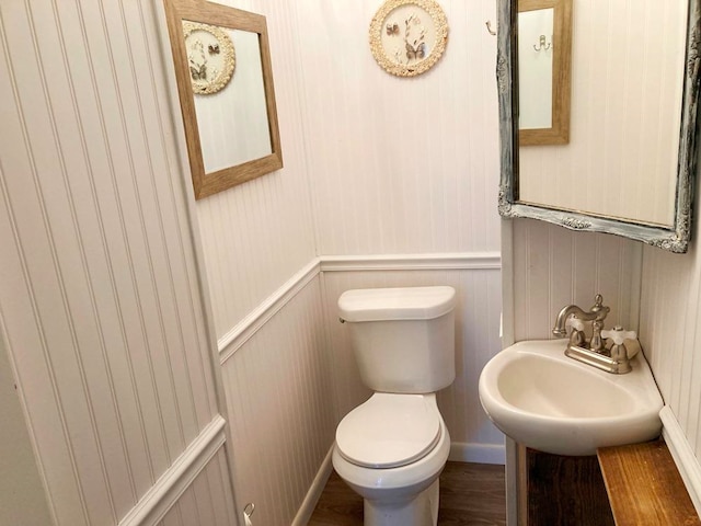 bathroom with hardwood / wood-style flooring, toilet, and sink