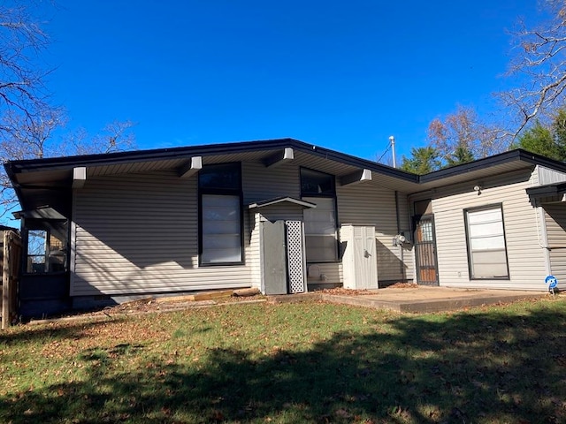 rear view of property featuring a lawn