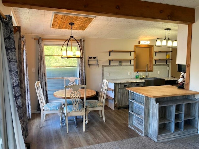 dining room featuring beamed ceiling, a chandelier, sink, and dark hardwood / wood-style flooring