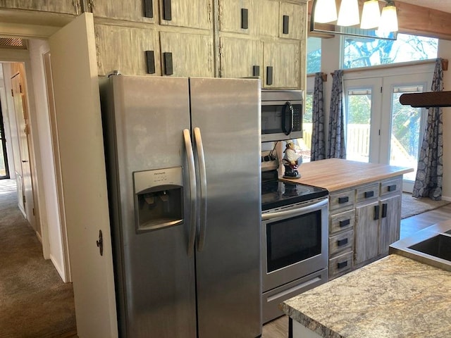 kitchen with lofted ceiling with beams, light brown cabinetry, light carpet, and stainless steel appliances