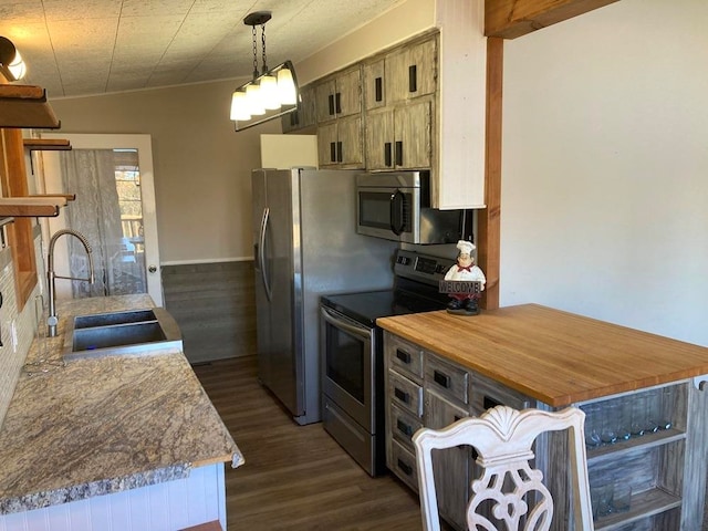 kitchen featuring appliances with stainless steel finishes, dark hardwood / wood-style flooring, pendant lighting, sink, and kitchen peninsula