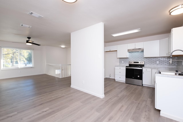 kitchen with white cabinets, sink, light hardwood / wood-style flooring, and electric stove