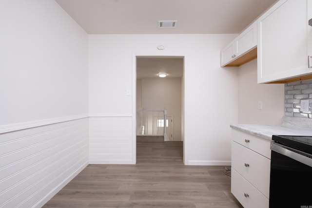 kitchen featuring white cabinetry, stainless steel electric stove, and light hardwood / wood-style flooring