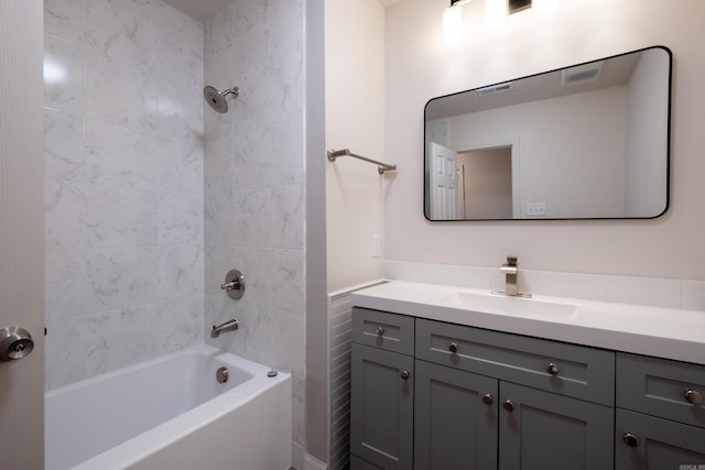 bathroom featuring tiled shower / bath combo and vanity