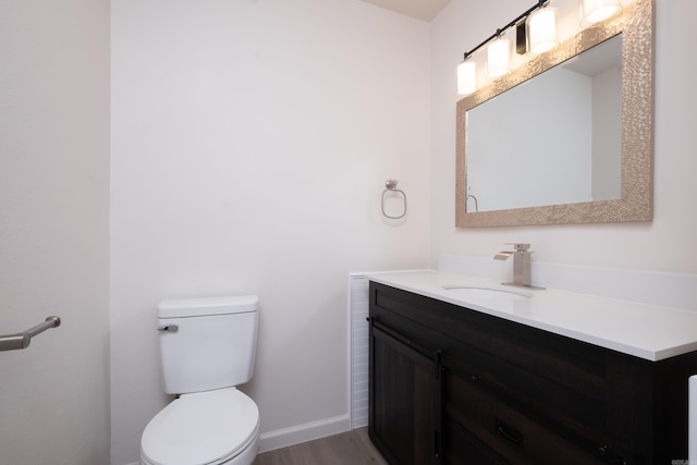 bathroom with wood-type flooring, toilet, and vanity