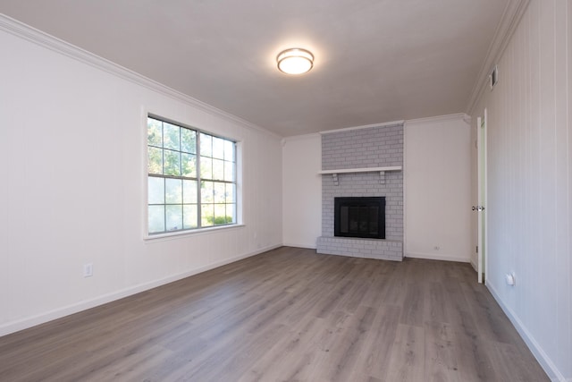 unfurnished living room featuring ornamental molding, light hardwood / wood-style floors, and a brick fireplace