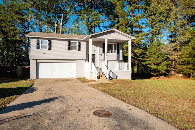 split foyer home featuring a garage, a front yard, and a porch