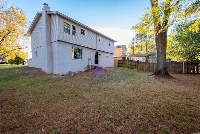 rear view of property featuring a lawn