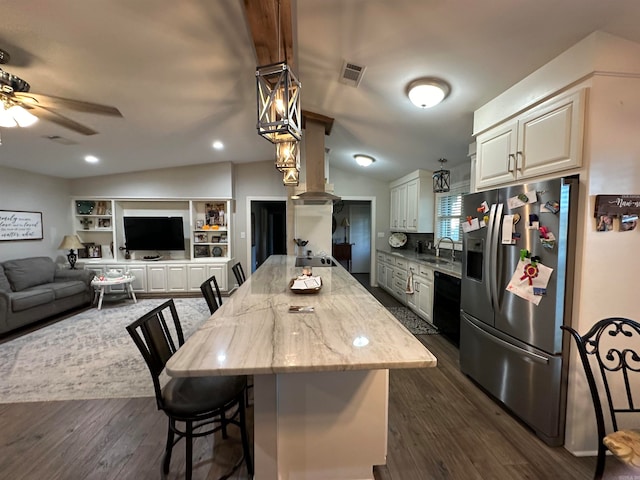 kitchen with a kitchen breakfast bar, light stone countertops, stainless steel fridge with ice dispenser, and dark wood-type flooring