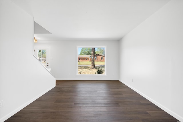 unfurnished room with dark wood-type flooring