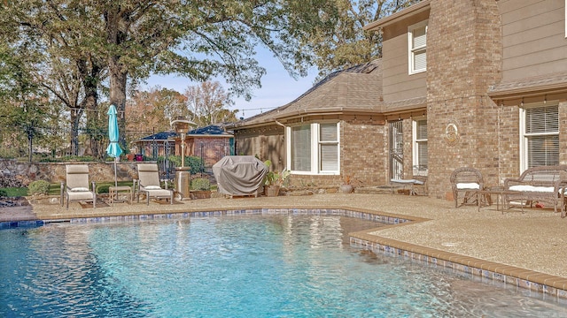 view of pool with grilling area and a patio area