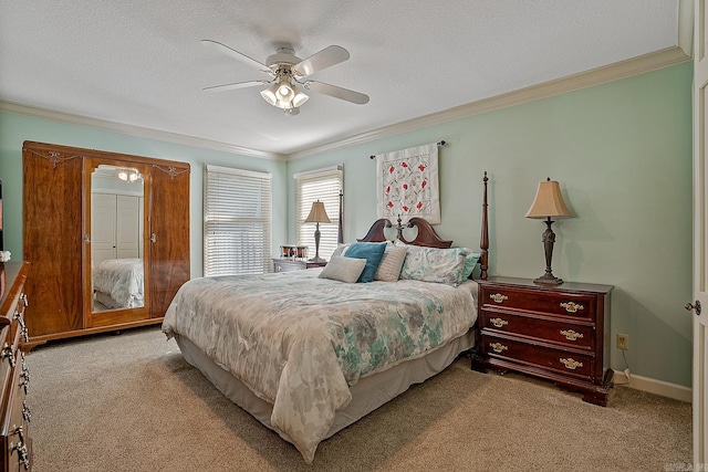 carpeted bedroom with a textured ceiling, ornamental molding, and ceiling fan