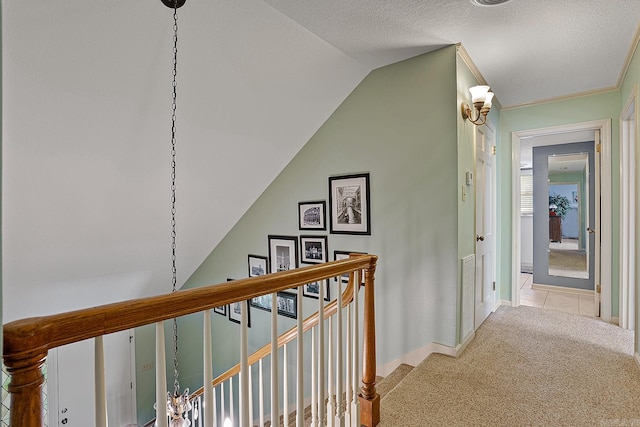 hall with vaulted ceiling, light colored carpet, and a textured ceiling