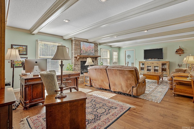 living room with crown molding, a fireplace, a textured ceiling, beamed ceiling, and light hardwood / wood-style flooring