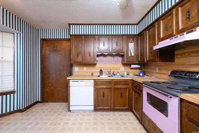 kitchen with white appliances, a textured ceiling, and sink