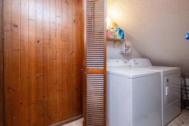 laundry room with wooden walls and washing machine and clothes dryer