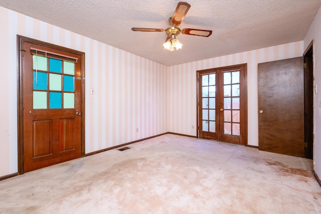 unfurnished room with french doors, light colored carpet, and a textured ceiling