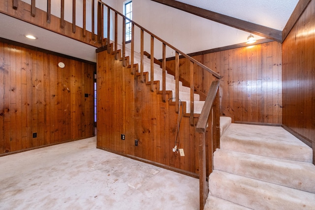 staircase with wooden walls and concrete floors