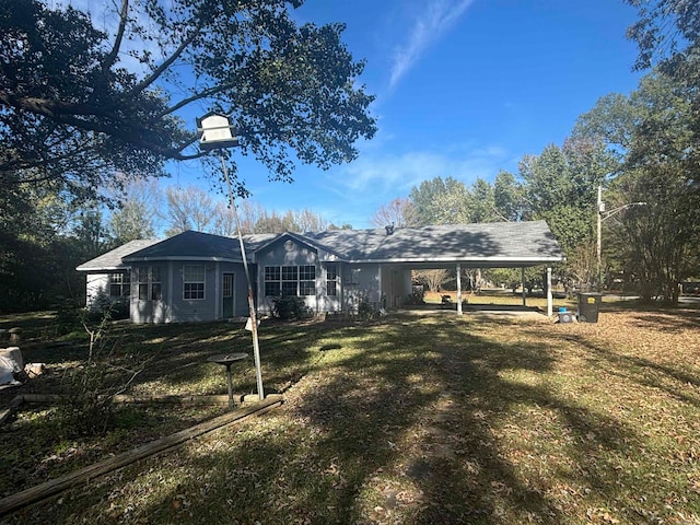 back of house with a lawn and a carport