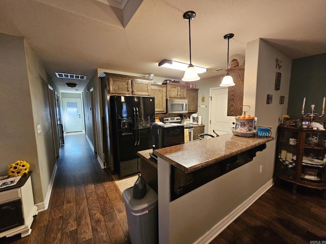 kitchen with appliances with stainless steel finishes, decorative light fixtures, dark hardwood / wood-style flooring, a breakfast bar, and kitchen peninsula